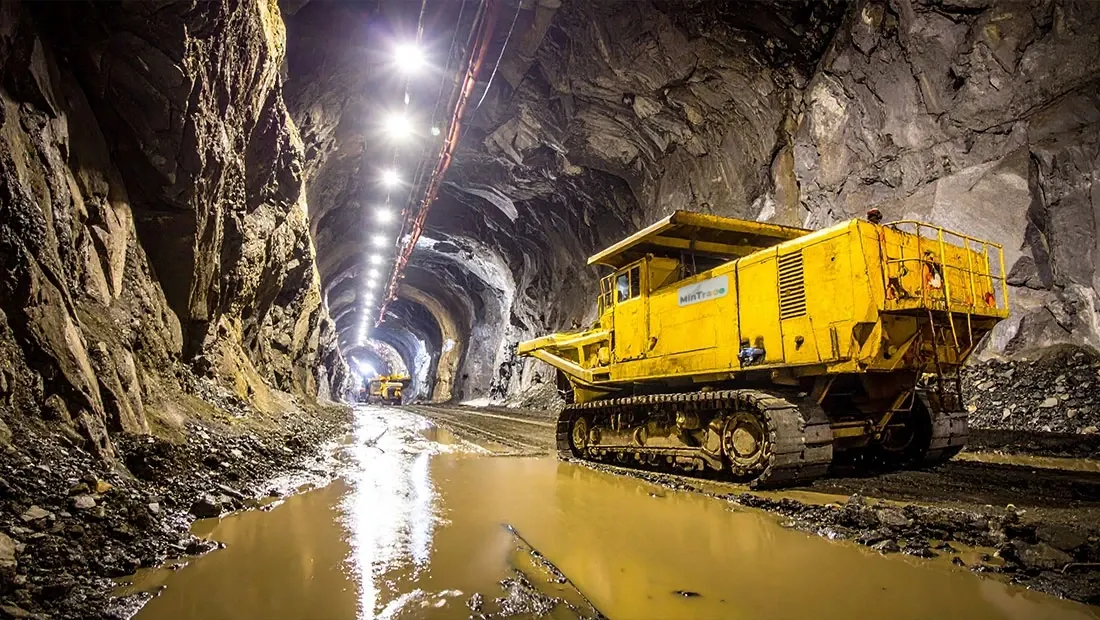 Túnel de mina iluminado con una máquina de carga